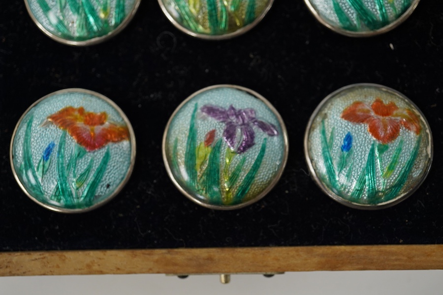 An early 20th century cased set of 6 Japanese white metal buttons, enamelled with irises, 22mm. Condition - good